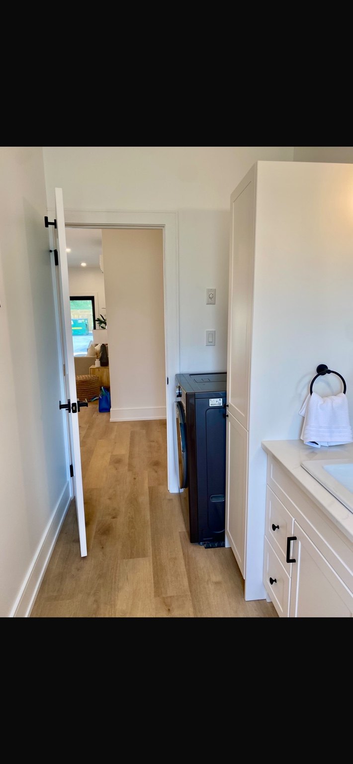 Bright interior showing laundry appliance and cabinetry